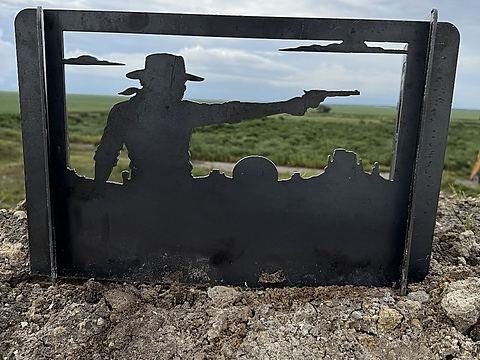 Steel fire pit panel with an Old-West gunslinger drawing his pistol over a frontier town
