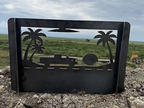 Steel fire pit panel with a pickup truck rolling past palm trees into the sunset